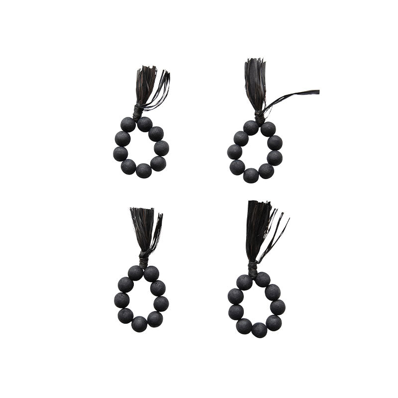 S/4 2-1/4RND WOOD BEAD NAPKINRINGS W RAFFIA TASSEL, BLACK - CREATIVE COOP - Compralo en CorinneRegalos.com