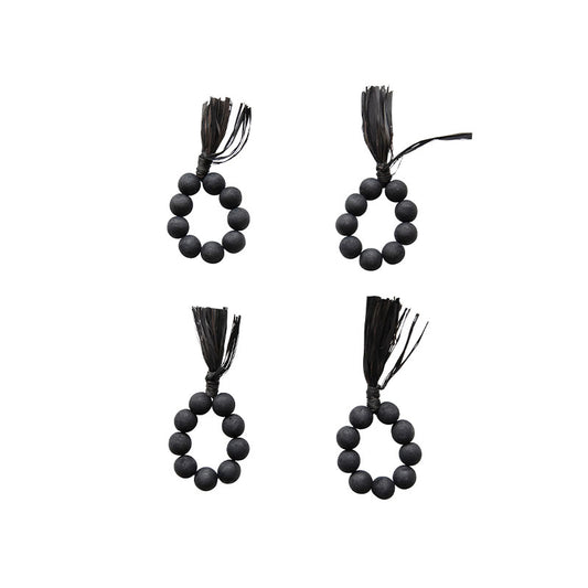 S/4 2-1/4RND WOOD BEAD NAPKINRINGS W RAFFIA TASSEL, BLACK - CREATIVE COOP - Compralo en CorinneRegalos.com